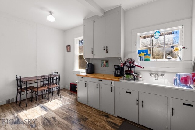 220 4th Ave E, Three Forks, MT 59752 - kitchen with white cabinets, a sink, wooden counters, beam ceiling, and wood finished floors
