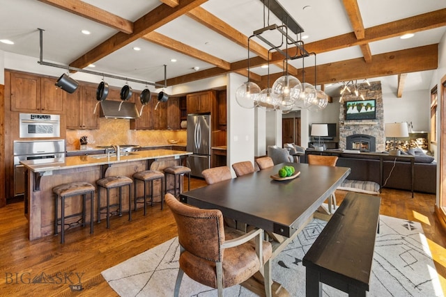 2430 Two Gun White Calf Rd, Big Sky, MT 59716 - dining room with beam ceiling, wood finished floors, a stone fireplace, coffered ceiling, and recessed lighting