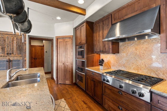 2430 Two Gun White Calf Rd, Big Sky, MT 59716 - kitchen featuring a sink, appliances with stainless steel finishes, exhaust hood, decorative backsplash, and beam ceiling