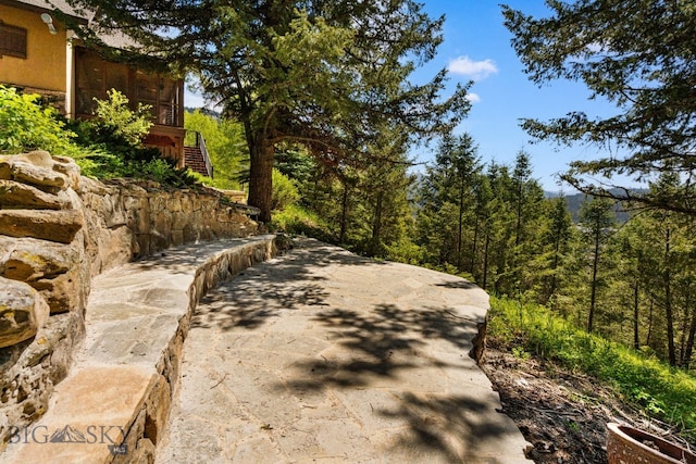 2430 Two Gun White Calf Rd, Big Sky, MT 59716 - view of concrete driveway featuring stairway and a wooded view