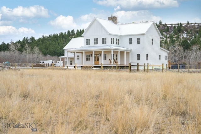 992 Deer Haven Dr, Deer Lodge, MT 59722 - rear view of house featuring a porch, metal roof, and a chimney