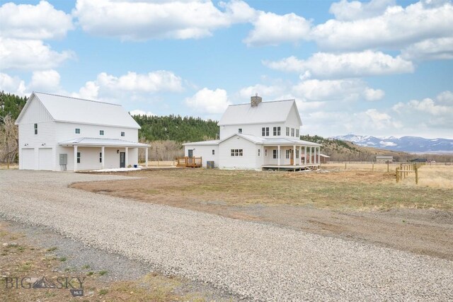992 Deer Haven Dr, Deer Lodge, MT 59722 - view of front of house with a garage, a porch, driveway, and metal roof