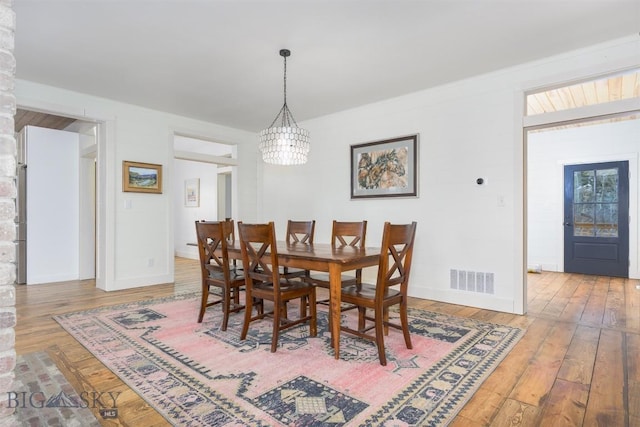 992 Deer Haven Dr, Deer Lodge, MT 59722 - dining space with hardwood / wood-style floors, a chandelier, and baseboards