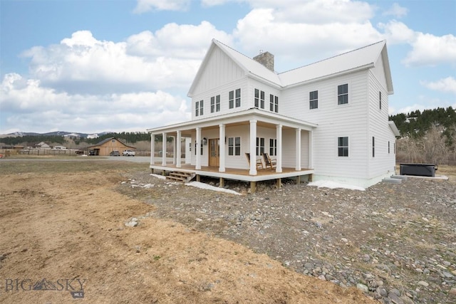 992 Deer Haven Dr, Deer Lodge, MT 59722 - view of front of house with a chimney, a porch, and board and batten siding