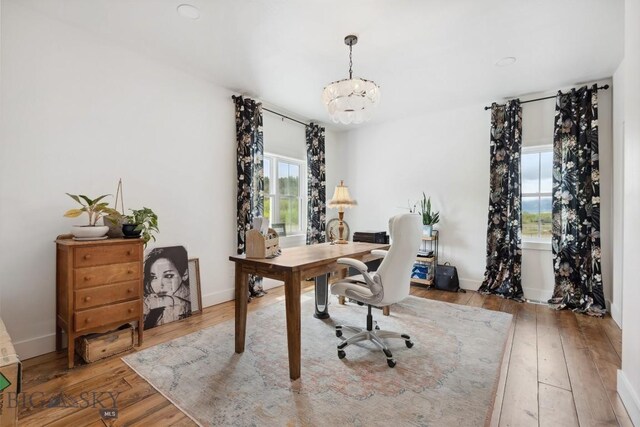 992 Deer Haven Dr, Deer Lodge, MT 59722 - home office featuring hardwood / wood-style flooring, a chandelier, and baseboards