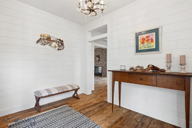992 Deer Haven Dr, Deer Lodge, MT 59722 - hall featuring a chandelier, dark wood finished floors, wooden walls, and ornamental molding