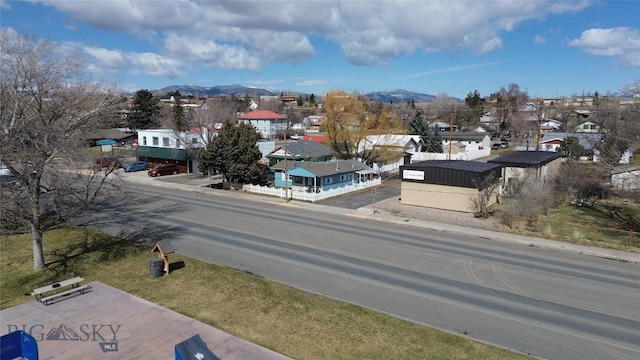 view of street with a mountain view, sidewalks, a residential view, and curbs