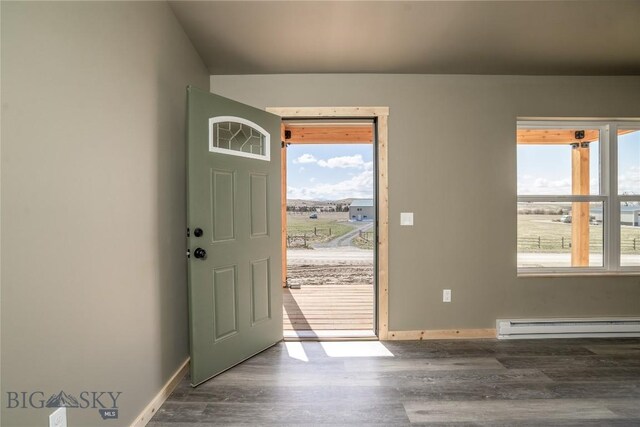 foyer featuring a baseboard heating unit, wood finished floors, and a wealth of natural light