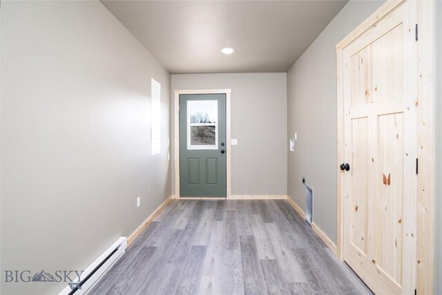 doorway to outside featuring baseboards and wood finished floors