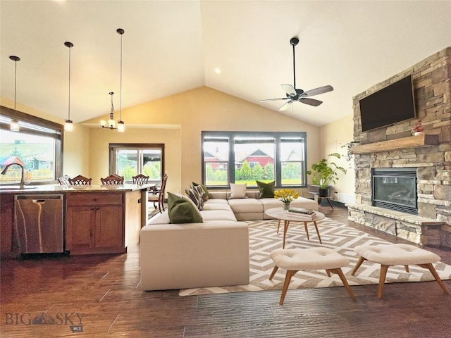 living room featuring high vaulted ceiling, a ceiling fan, a fireplace, and a healthy amount of sunlight