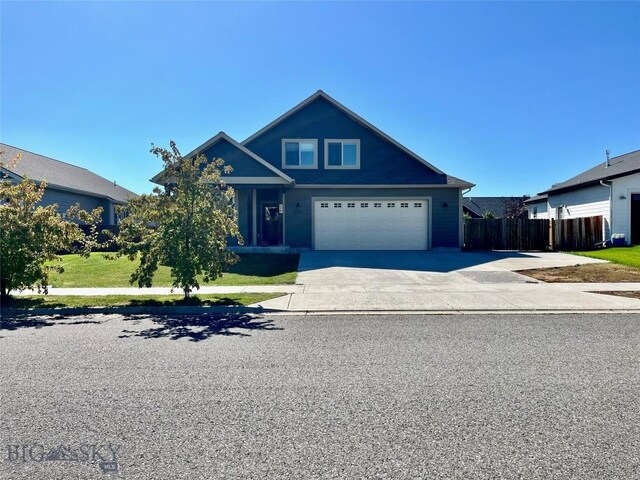 view of front facade featuring a garage, driveway, fence, and a front lawn