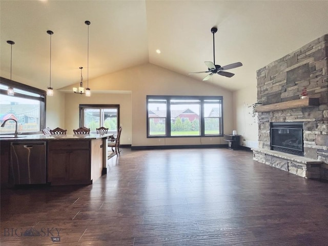 kitchen featuring open floor plan, stainless steel dishwasher, a sink, and a wealth of natural light