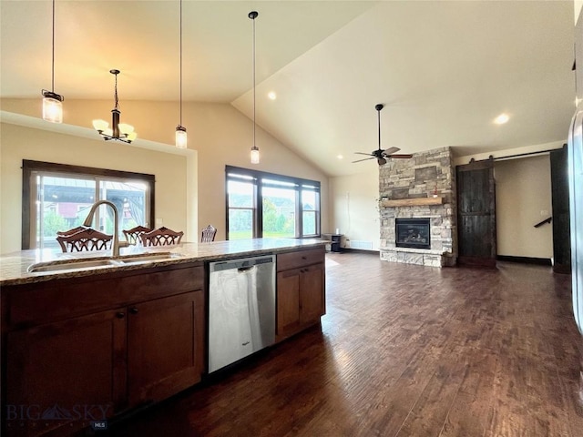 kitchen with a fireplace, light stone counters, dark wood-style flooring, dishwasher, and a sink