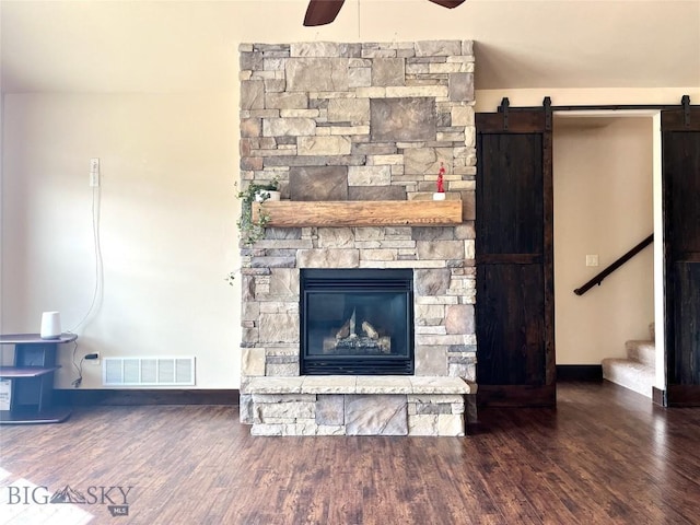 interior details with visible vents, a ceiling fan, wood finished floors, and a fireplace