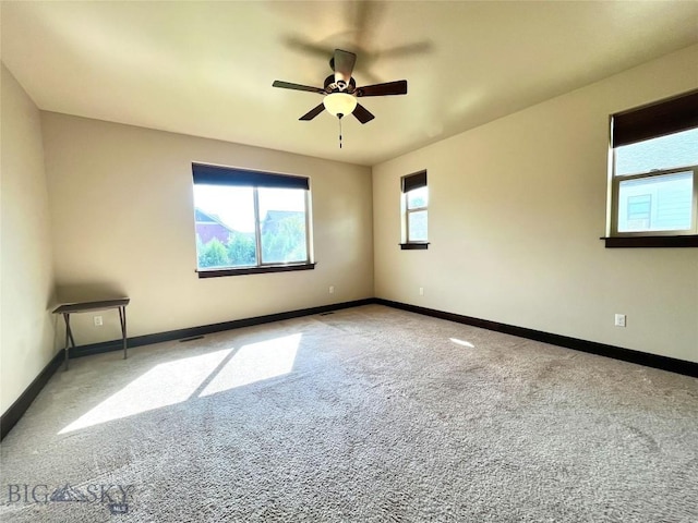 carpeted empty room featuring baseboards and a ceiling fan