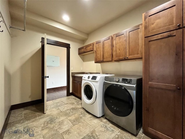 laundry room featuring separate washer and dryer, a sink, baseboards, and cabinet space