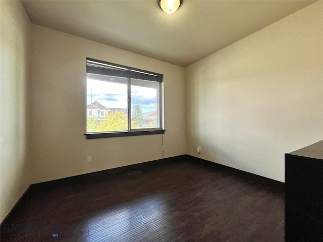 unfurnished room featuring dark wood-style flooring