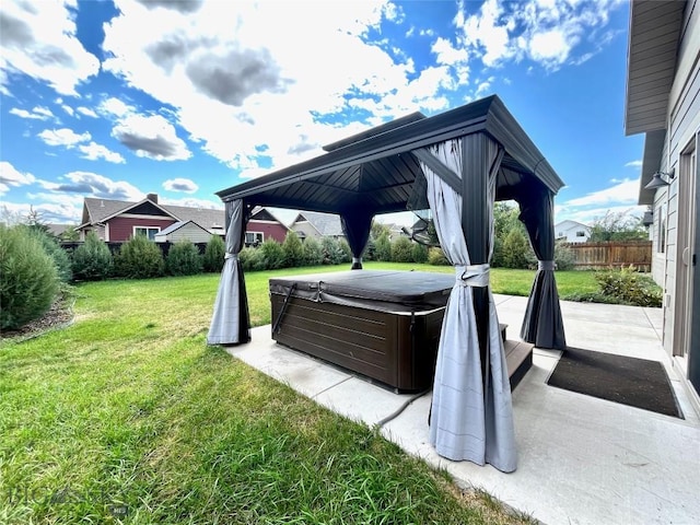 view of patio / terrace featuring a gazebo, fence, and a hot tub