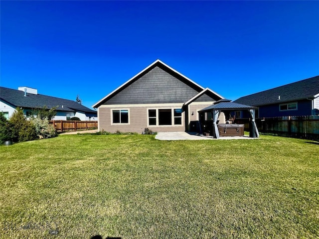 rear view of house with a patio area, a fenced backyard, a gazebo, and a hot tub