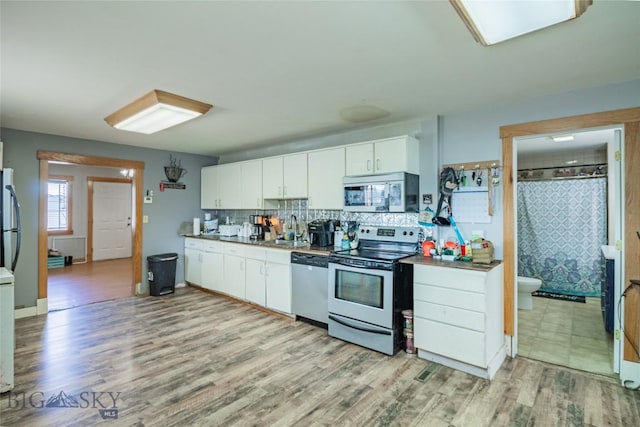 1916 S Jackson, Butte, MT 59701 - kitchen featuring light wood-style flooring, a sink, white cabinets, and stainless steel appliances