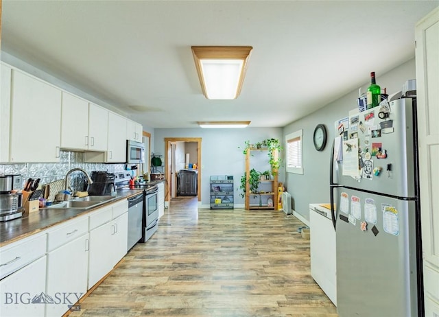 1916 S Jackson, Butte, MT 59701 - kitchen featuring light wood-style flooring, white cabinets, decorative backsplash, stainless steel appliances, and a sink
