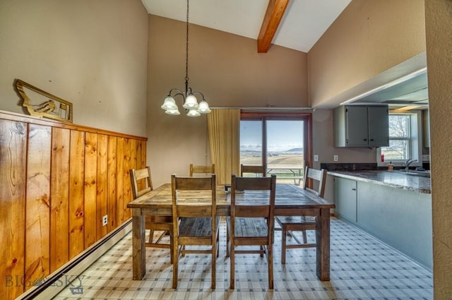 5585 W Cameron Bridge Rd, Manhattan, MT 59741 - dining space with a baseboard radiator, high vaulted ceiling, a chandelier, beam ceiling, and wood walls