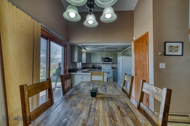 5585 W Cameron Bridge Rd, Manhattan, MT 59741 - kitchen featuring white appliances, a chandelier, a peninsula, baseboard heating, and wood finished floors