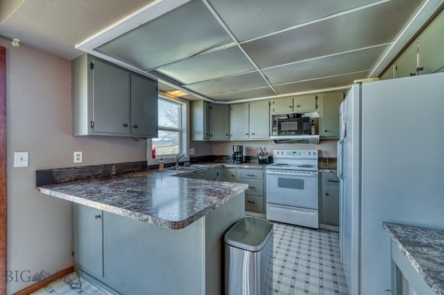 5585 W Cameron Bridge Rd, Manhattan, MT 59741 - kitchen featuring white appliances, a peninsula, light flooring, and dark countertops