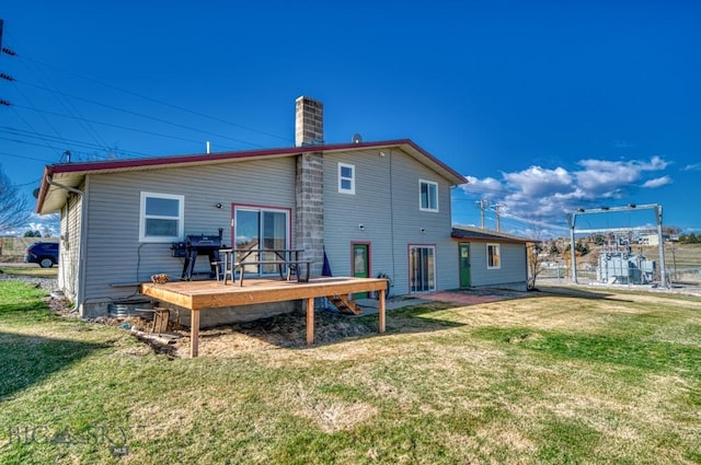 5585 W Cameron Bridge Rd, Manhattan, MT 59741 - back of property featuring a wooden deck, a chimney, and a lawn