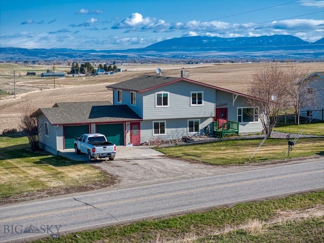 5585 W Cameron Bridge Rd, Manhattan, MT 59741 - view of front facade featuring driveway, an attached garage, a mountain view, and a front lawn