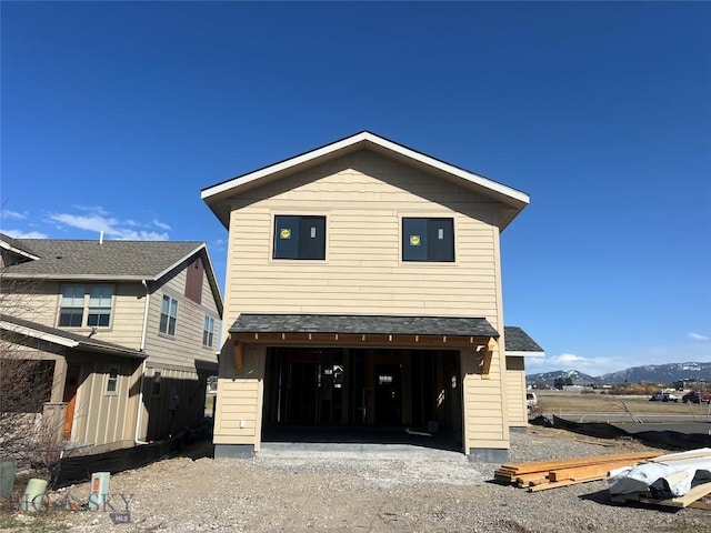 view of front facade featuring a garage, driveway, and a mountain view