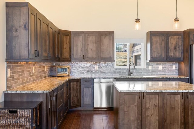 9 Cedar Ct, Ennis, MT 59751 - kitchen with stainless steel dishwasher, dark wood-style floors, decorative backsplash, pendant lighting, and light stone countertops
