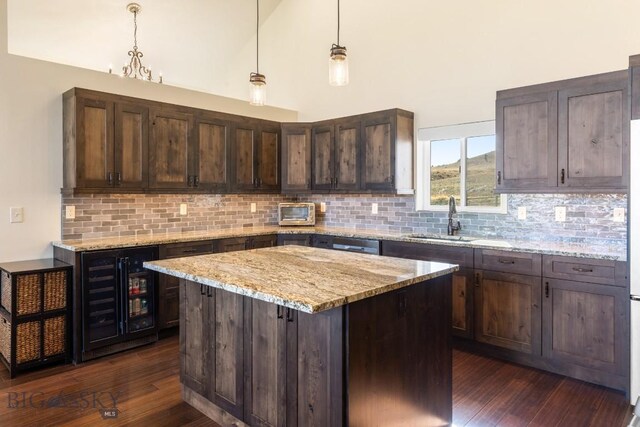 9 Cedar Ct, Ennis, MT 59751 - kitchen featuring beverage cooler, dark wood-style flooring, backsplash, dark brown cabinetry, and a towering ceiling