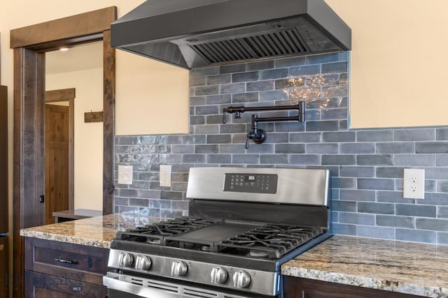 9 Cedar Ct, Ennis, MT 59751 - kitchen with stainless steel gas range, custom range hood, decorative backsplash, and light stone countertops