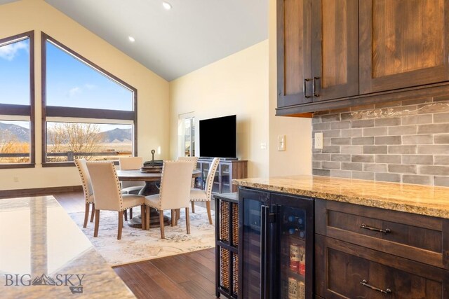 9 Cedar Ct, Ennis, MT 59751 - dining room with wine cooler, dark wood-style flooring, lofted ceiling, and a dry bar