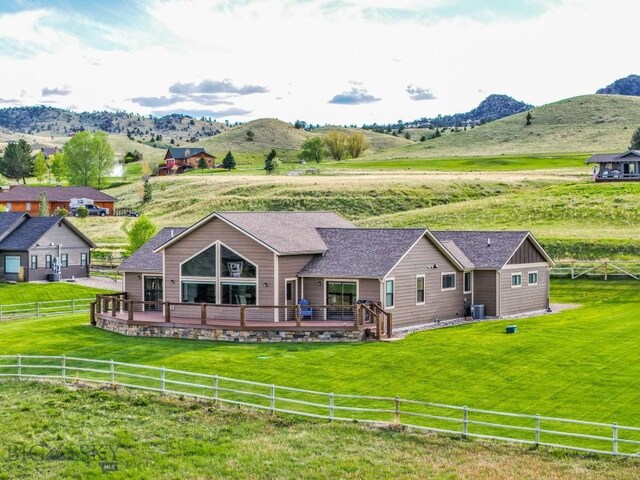 9 Cedar Ct, Ennis, MT 59751 - rear view of house featuring a view of rural / pastoral area, a fenced backyard, a deck with mountain view, and a shingled roof