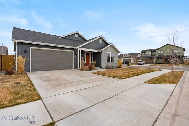 view of front facade with roof with shingles, driveway, a garage, a front lawn, and board and batten siding