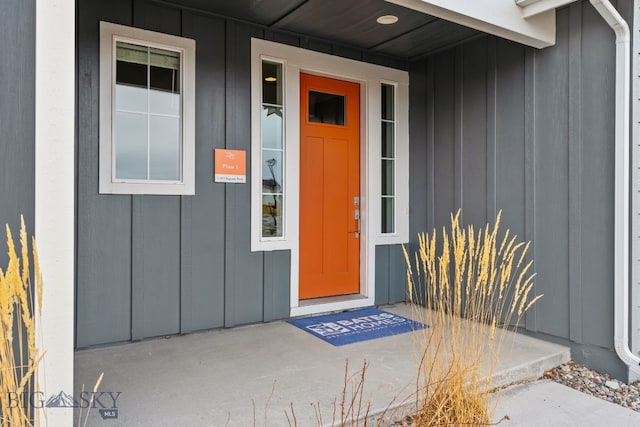 view of exterior entry featuring board and batten siding and a porch
