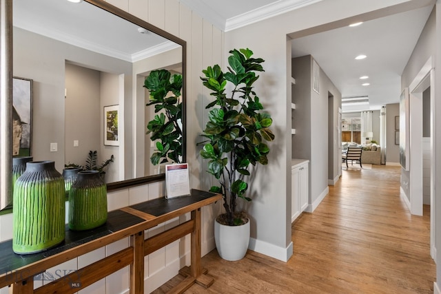 hall with crown molding, light wood-type flooring, baseboards, and recessed lighting
