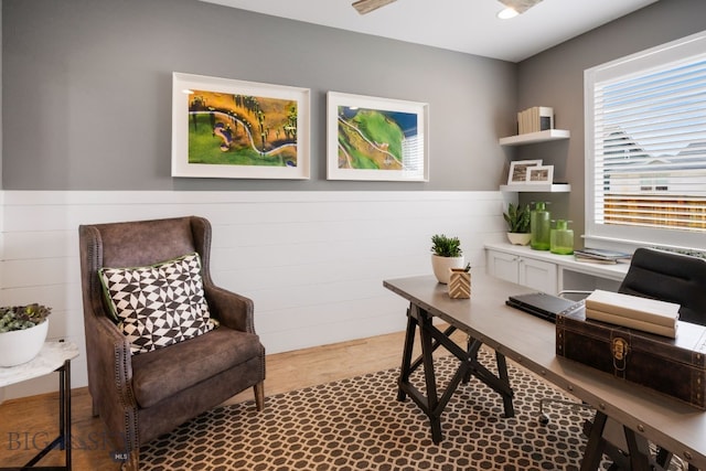 home office featuring a wainscoted wall and wood finished floors