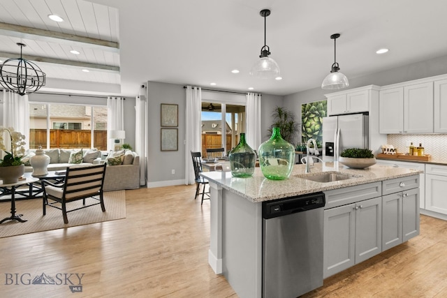 kitchen with a sink, decorative light fixtures, appliances with stainless steel finishes, tasteful backsplash, and recessed lighting