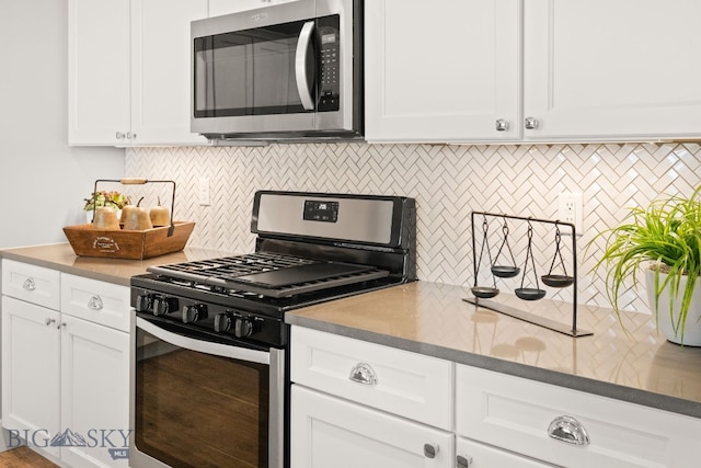 1516 Wild Bill Way, Belgrade, MT 59714 - kitchen featuring stainless steel appliances, decorative backsplash, and white cabinetry