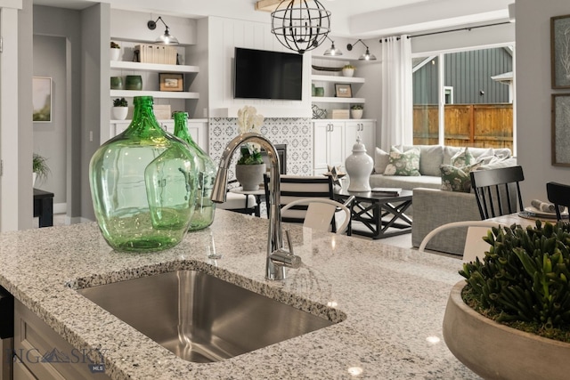 1516 Wild Bill Way, Belgrade, MT 59714 - kitchen featuring a sink, stone countertops, a chandelier, and open floor plan