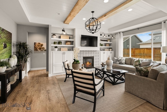 1516 Wild Bill Way, Belgrade, MT 59714 - living area with wood finished floors, a tile fireplace, recessed lighting, baseboards, and a chandelier