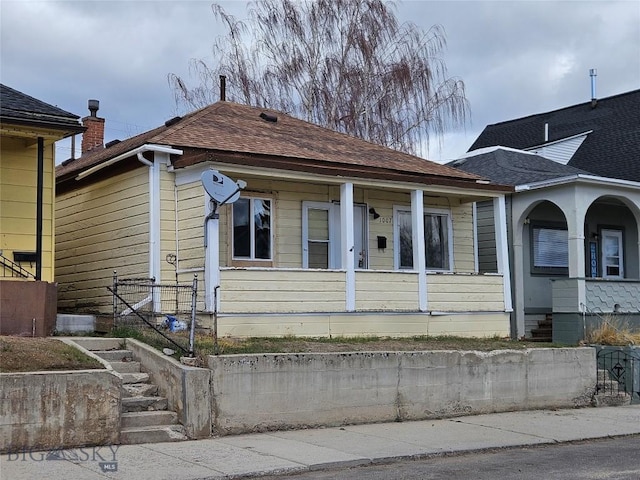 bungalow with a porch and a shingled roof