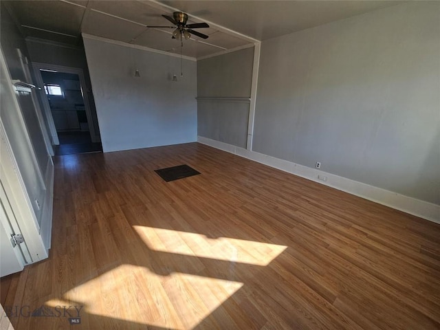 unfurnished room featuring baseboards, wood finished floors, and ceiling fan