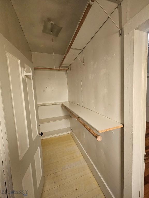 walk in closet featuring attic access and light wood-style flooring