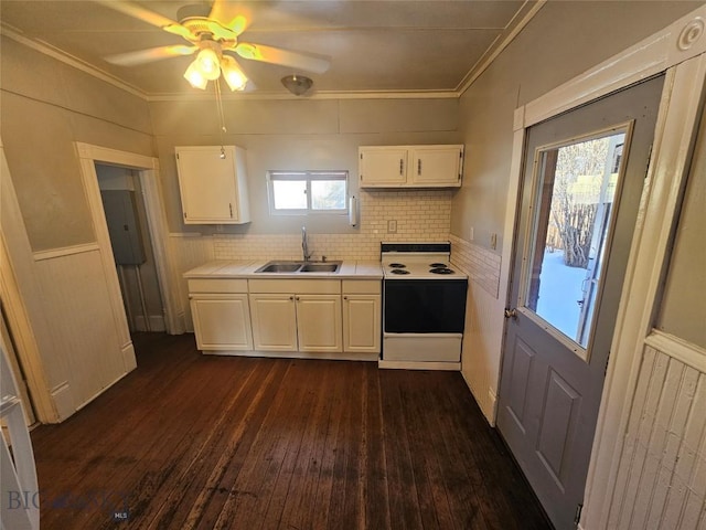 kitchen with range with electric cooktop, light countertops, white cabinets, a sink, and dark wood-type flooring