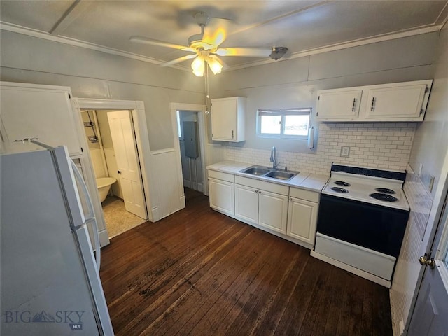 kitchen featuring freestanding refrigerator, range with electric stovetop, white cabinets, a sink, and dark wood-style floors