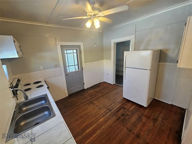 kitchen with dark wood-style floors, a sink, ceiling fan, white appliances, and ornamental molding